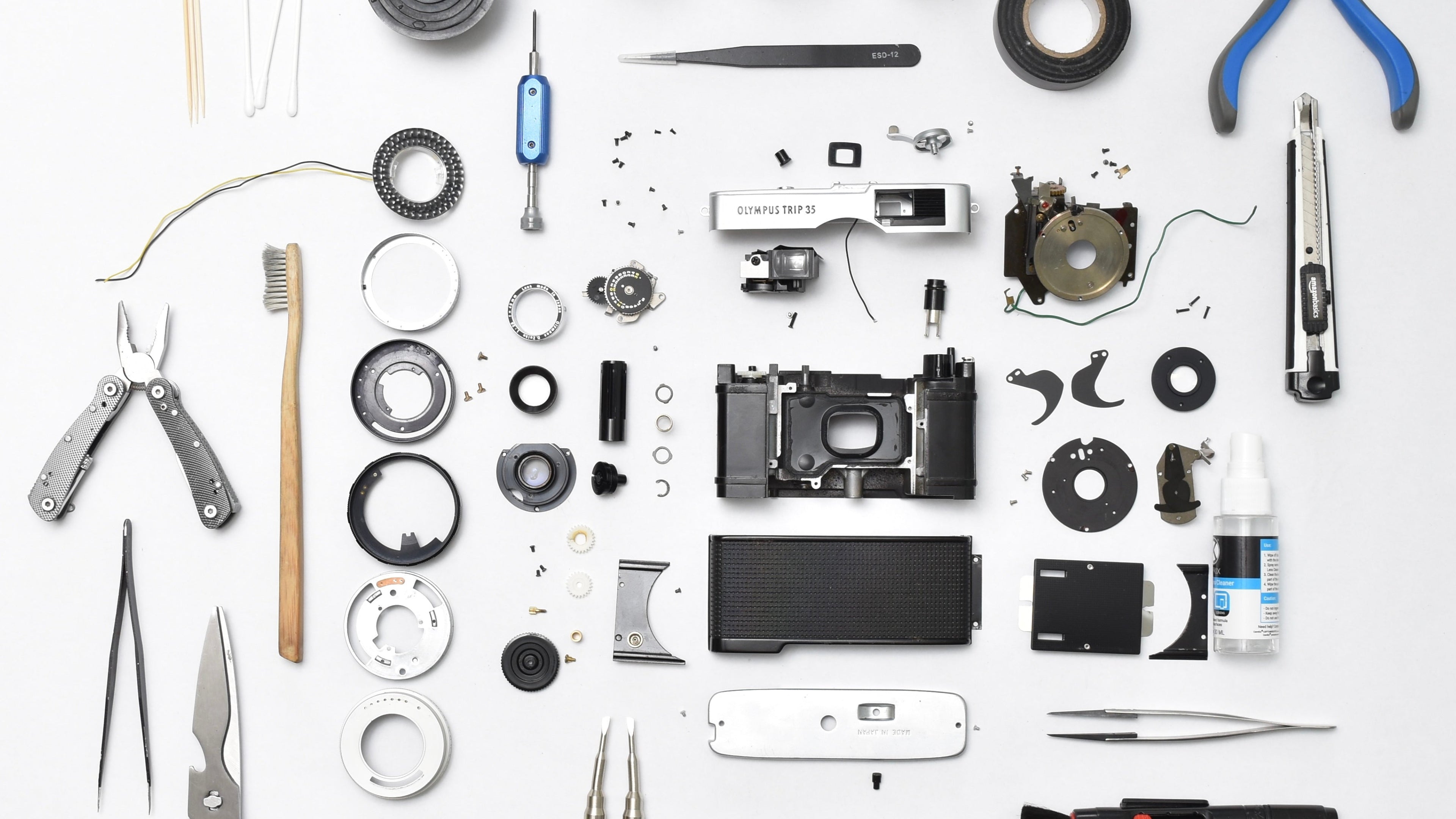 Collection of camera parts and tools on a white background